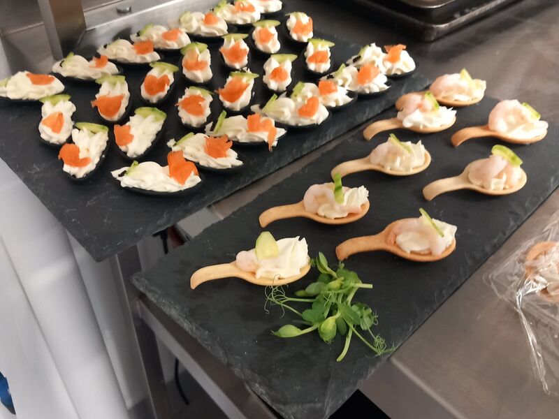 Smoked salmon and creme fraiche canapes on porcelain spoons, set out on slate