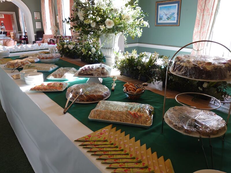 A long buffet table of sandwiches, savouries and cakes running the length of a hall